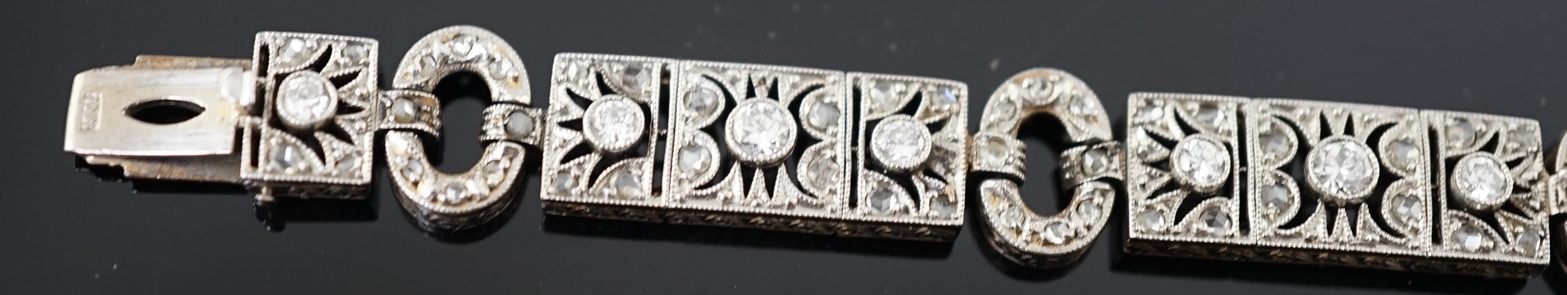 A 1920's pierced 18ct white gold and millegrain set round and rose cut diamond cluster bracelet